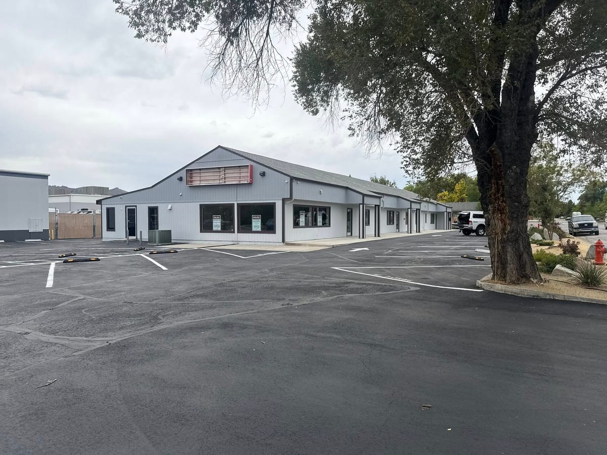 The Carson City BBQ event center building and its parking lot, with a mature tree beside the entrance